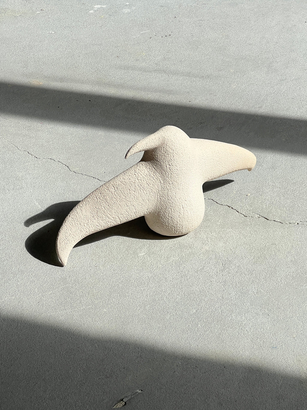 Close-up shot of the "Bird" ceramic art sculpture highlighting the textured stoneware surface and color transition.