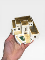 Custom hand-sculpted ceramic model of a modern white Mediterranean villa with terraced levels and steps.