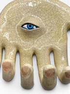 Close-up macro detail of the blue ceramic eye and the delicate Japanese Kanyū crackle glaze texture on the Eye Hand wall hanger.