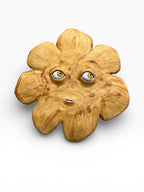 Artisan ceramic wall mask in the shape of a sun with textured rays, made from Belgian Sibelco stoneware and golden glazes

