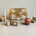 Detailed view of an artisan ceramic mask with golden texture and hand-painted flowers, contemporary wall art from Ukraine.