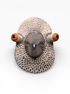 Close-up of a handmade ceramic bird mask showing expressive eyes and textured artisanal finish, size 20x15cm