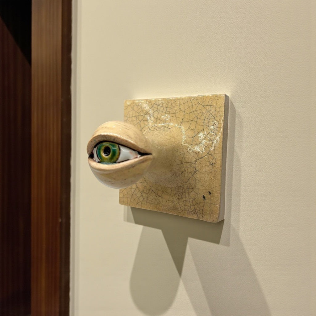 Detailed view of a unique ceramic green eye hook showing textured crackle finish and artisanal iris painting, 10x10cm.