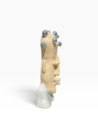 Right side profile of an elongated ceramic bust showing textured stoneware and a unique crown of glazed spheres.