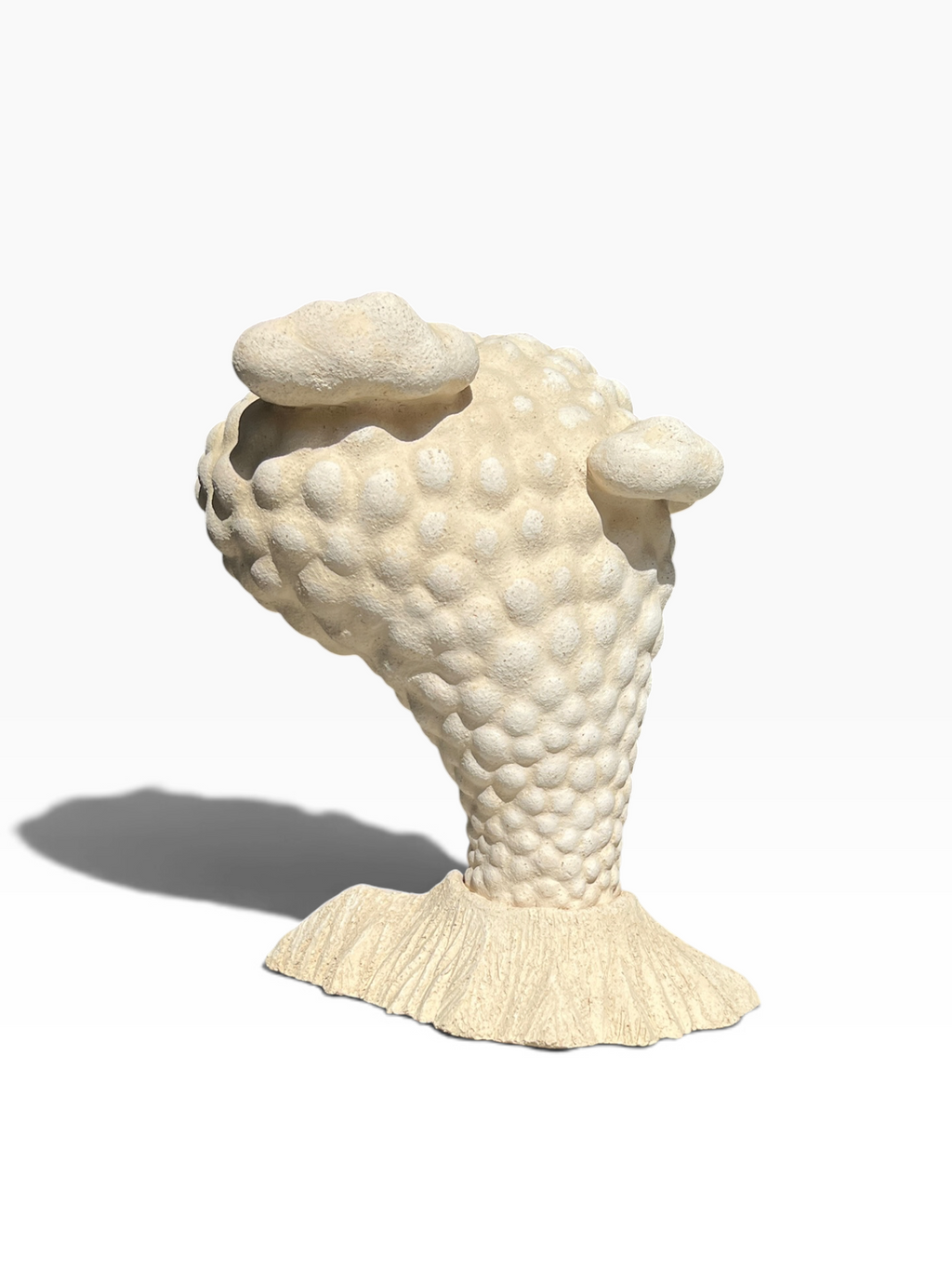 Side angle of the biomorphic "Volcano" sculpture showcasing its dynamic curved silhouette and matte stone texture.